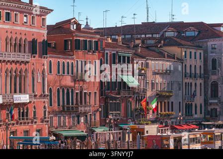 Venedig, Italien 24. September 2026. Historische Ufergebäude zeigen farbenfrohe Fassaden, kunstvolle gotische Details, Dachantennen, Markisen, italienische Flaggen Stockfoto