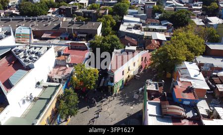 Luftaufnahme der farbenfrohen Gebäude und Kopfsteinpflasterstraßen des Caminito in La Boca mit Menschen, die unten in Buenos Aires, Buenos Aires, Argentinien spazieren Stockfoto