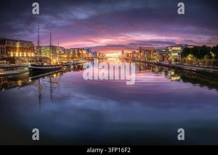Luftaufnahme des Flusses Liffey bei Sonnenaufgang mit dem Tall Ship Jeanie Johnston, das am Kai in Dublin, County Dublin, Irland, vertäut ist Stockfoto