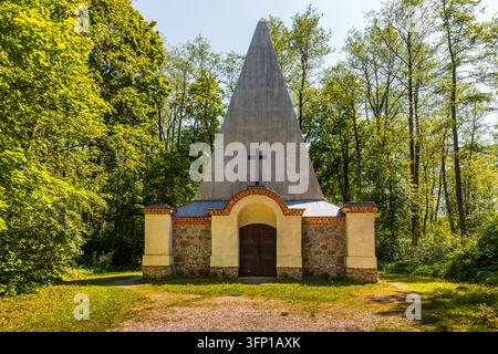 Mausoleumsstruktur der Familie Fahrenheid mit einer Pyramidenform und einem Kreuz, umgeben von grünen Bäumen in Rapa, Polen Stockfoto