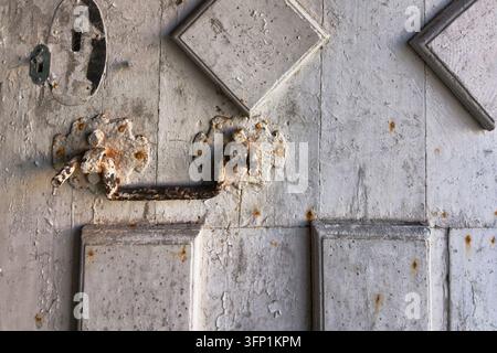 Detail eines verrosteten Metallgriffs an einer sehr alten weiß gestrichenen Tür, Museum der Abtei Mortemer Stockfoto