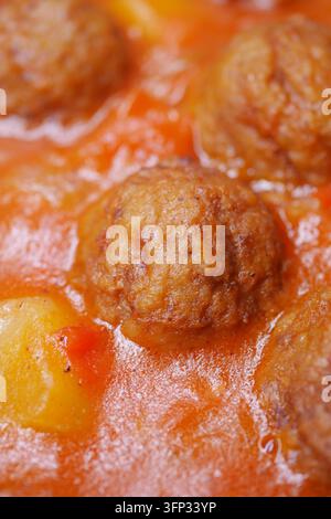 Köstliche Fleischbällchen in Sauce mit Gemüse und Kartoffeln, die in einem Topf kochen Stockfoto