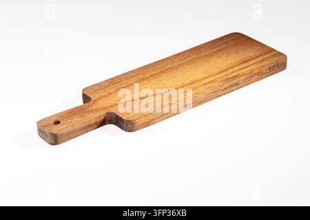 Schmale handgefertigte Holzleiste mit Aufhängeloch und warmer brauner Maserung, isoliert auf schlichtem weißem Hintergrund. Leere Oberfläche für Küche und Geschirrdes Stockfoto