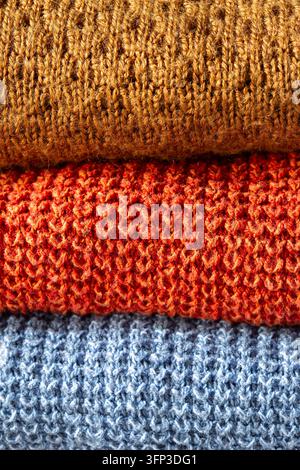 Gestrickte Wollpullover, die aufeinander gestapelt sind. Herbst-Winter-Kleidungskonzept Stockfoto