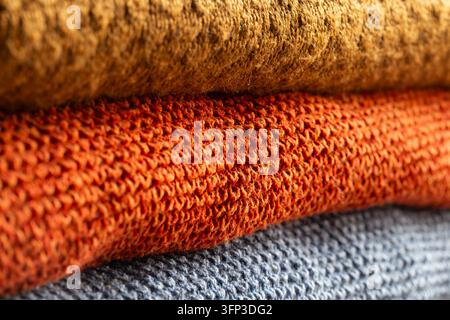 Gestrickte Wollpullover, die aufeinander gestapelt sind. Herbst-Winter-Kleidungskonzept Stockfoto