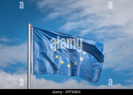 Die Flagge der Europäischen Union weht im Wind und präsentiert ihr aufwendiges Design und den lebendigen blauen Hintergrund. Stockfoto