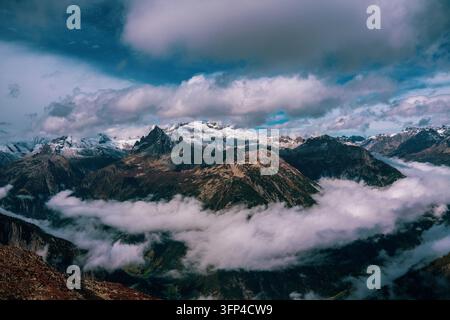 Schweizer Alpenlandschaft mit schneebedeckten Gipfeln, umgeben von Wolken Stockfoto