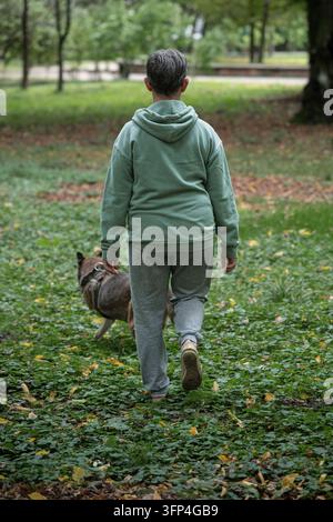 Frau geht mit Hund im grünen Park Stockfoto