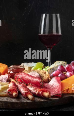 Antipasti oder Tapas. Wurst- und Käseplatte mit Wein, Seitenansicht mit Kopierraum Stockfoto