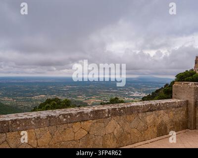 Steinerne Festungsmauern umrahmen weitläufige Landschaften vom historischen Santuari Sant Salvador-Kloster, das hoch über Mallorcas östlichen Ebenen thront Stockfoto