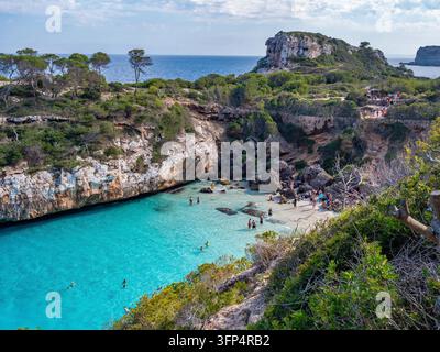 CalAÂ³ des Moro präsentiert kristallklare türkisfarbene Gewässer, umgeben von dramatischen Kalksteinklippen und mediterraner Vegetation. Touristen schwimmen und entspan Stockfoto