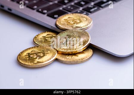 Bitcoin-Kryptowährungsmünzen auf Laptop-Tastatur, Kryptowährung und digitalem Zahlungssystem, Nahaufnahme Stockfoto