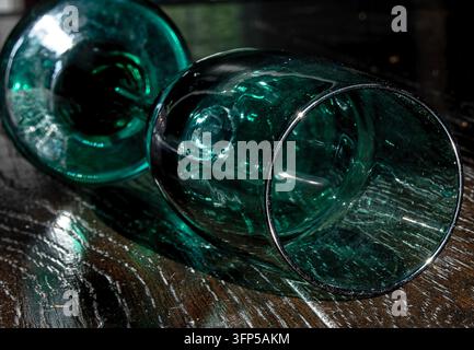 Ein Vintage-Libbey Premiere Juniper Green-Weinglas mit einer satten, tiefen blaugrünen Schale und einer glatten, abgerundeten Silhouette, das auf dem Tisch steht. Stockfoto