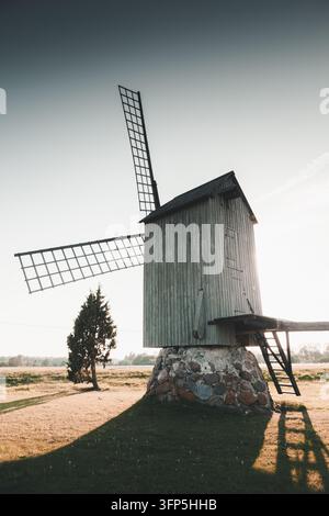 Blick auf Ratsepa tuulik, eine historische hölzerne Windmühle auf steinernem Fundament in einer Wiese während der goldenen Stunde in Harju, Hiiu County, Estland. Stockfoto