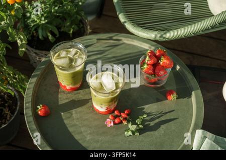 Erdbeer-Matcha-Lattes auf einem Sommergartentisch, Ansicht von oben Stockfoto