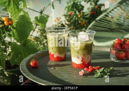 Zwei Erdbeer-Matcha-Lattes im Sommergarten Stockfoto