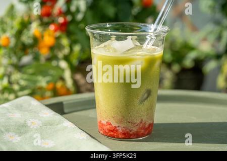 Erfrischender geschichteter Erdbeer-Matcha-Latte mit Eis Stockfoto