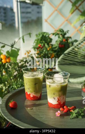Erdbeer-Matcha-Lattes auf einem sonnigen Gartentisch Stockfoto