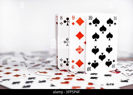 Spielkarten aufrecht stehend mit verstreuten Karten auf weißem Hintergrund Stockfoto