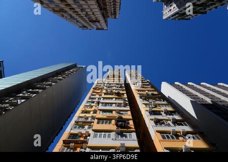 Wohnanlage für Sozialwohnungen mit hoher Dichte in Hongkong. Straßenansicht nach oben gerichtet. Wohnhäuser im Viertel Mong Kok von Kowloon, Hongkong. Stockfoto