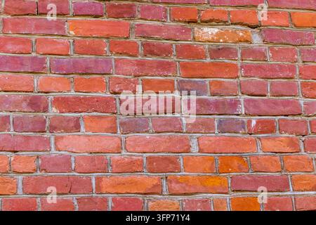 Verwitterte rote Ziegelwandoberfläche in einer perspektivischen Seitenansicht Stockfoto