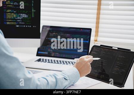 Programmierer schreibt Programmcode mit zwei Monitoren Programmieranalyse arbeitet mit Softwarecode zur Problemlösung. Entwicklung von Softwareanwendungen Stockfoto