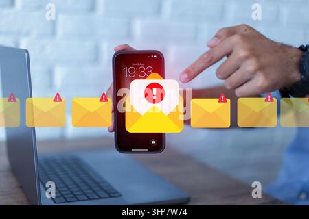 Mann hält ein Smartphone mit einer E-Mail-Warnmeldung auf dem Bildschirm. Konzept für Cybersicherheit, Phishing-Angriff, Spam-Mail, digitalen Betrug und Online Stockfoto