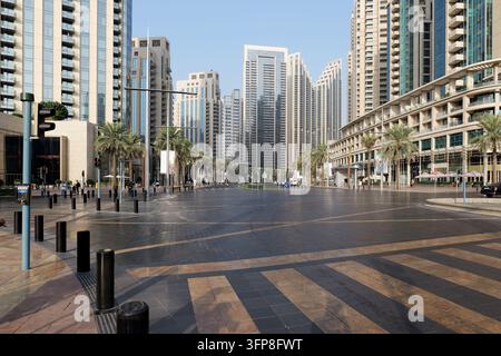 Dubai, VAE - 5. Februar 2026. Breite leere Straße in Downtown Dubai mit modernen Türmen und Palmen, die das ruhige Stadtleben, Ordnung und Komfort in einem Stockfoto