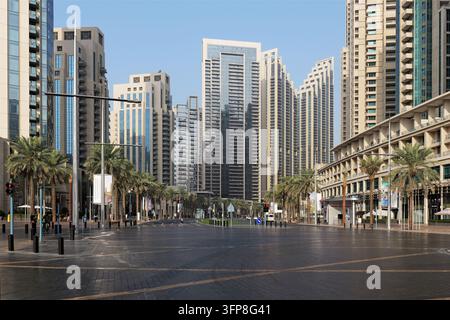 Dubai, VAE - 5. Februar 2026. Breite leere Straße in Downtown Dubai mit modernen Türmen und Palmen, die das ruhige Stadtleben, Ordnung und Komfort in einem Stockfoto