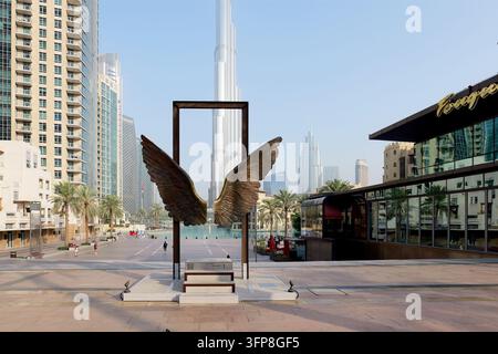 Dubai, VAE - 5. Februar 2026. Weitwinkelaufnahme einer Engelsflügel-Skulptur mit Burj Khalifa im Hintergrund auf einer leeren städtischen Straße, Downtown Dubai, Reisen Stockfoto