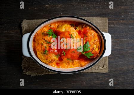 Hausgemachte Fleischbällchen in Tomatensoße serviert in einer Keramikschale von oben. Gebackene Fleischbällchen oder Schnitzel mit roter Sauce und frischen Kräutern. Köstliches Traditionelles h Stockfoto