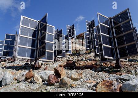 Detail von Solarmodulen in den Bergen vertikal montiert wie vier Flügel um eine zentrale Säule wie ein Baum, Photovoltaikanlage vermeidet Schneianhäufung, Zukunft Stockfoto