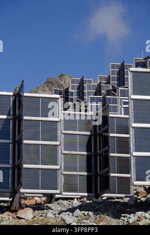 Detail von Solarmodulen in den Bergen vertikal montiert wie vier Flügel um eine zentrale Säule wie ein Baum, Photovoltaikanlage vermeidet Schneianhäufung, Zukunft Stockfoto