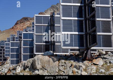 Detail von Solarmodulen in den Bergen vertikal montiert wie vier Flügel um eine zentrale Säule wie ein Baum, Photovoltaikanlage vermeidet Schneianhäufung, Zukunft Stockfoto