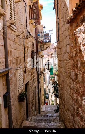 Blick auf eine schmale Steinwegge mit historischer Architektur, Holzläden und hängenden Laternen in der Altstadt von Hvar, Gespanschaft Split-Dalmatien, Kroatien Stockfoto