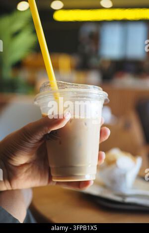 Mann hält einen Eiskaffee in einem Café am Tag Stockfoto