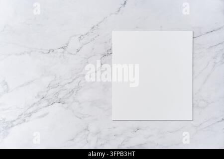 Obenansicht einer Sequenz von einer offenen zu einer geschlossenen leeren weißen Grußkarten-Vorlage auf Marmorhintergrund mit Platz für Text: leere weiße quadratische Karte. Stockfoto
