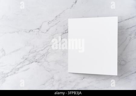 Oberblick-Sequenz von offen zu geschlossen, leeres weißes Grußkarten-Mockup auf Marmorhintergrund mit Kopierraum: Öffnen einer leeren weißen gefalteten Grußkarte Stockfoto