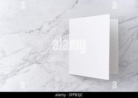 Oberblick-Sequenz von offen zu geschlossen, leeres weißes Grußkarten-Mockup auf Marmorhintergrund mit Kopierraum: Öffnen einer leeren weißen gefalteten Grußkarte Stockfoto