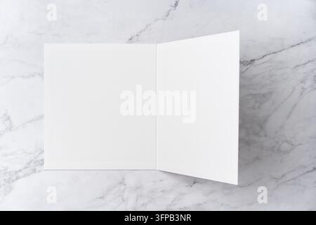 Oberblick-Sequenz von offen zu geschlossen, leeres weißes Grußkarten-Mockup auf Marmorhintergrund mit Platz für Text: Schließen einer leeren weißen gefalteten Grußkarte Stockfoto