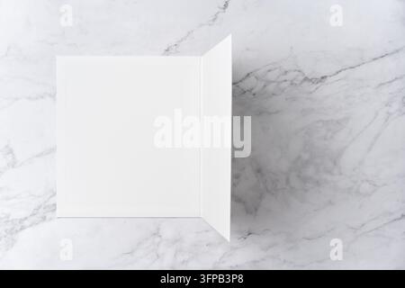 Oberblick-Sequenz von offen zu geschlossen, leeres weißes Grußkarten-Mockup auf Marmorhintergrund mit Platz für Text: Schließen einer leeren weißen gefalteten Grußkarte Stockfoto