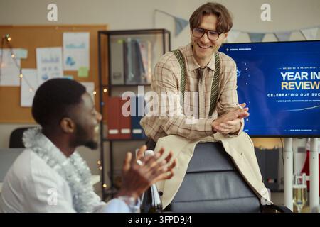 Geschäftsleute, die während einer Unternehmensbesprechung über Erfolg sprechen und feiern Stockfoto