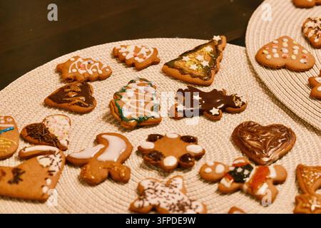 Ein bezaubernder Blick von oben auf frisch gebackene hausgemachte Weihnachtslebkuchen, sorgfältig verziert mit aufwendigen Mustern in Weiß und Bunt Stockfoto