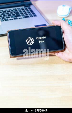 Hand, die ein Smartphone mit dem Open AI Sora App-Logo hält. Stockfoto