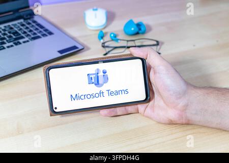 Hand, die ein Smartphone mit dem Microsoft Teams-App-Logo hält. Stockfoto