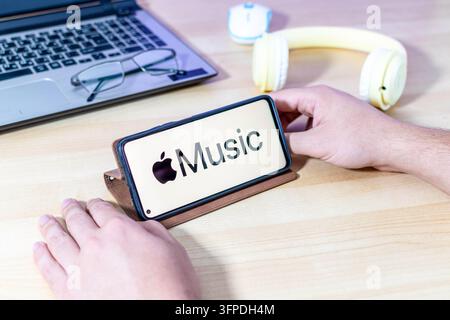 Hand, die ein Smartphone mit dem Apple Music-App-Logo hält. Stockfoto