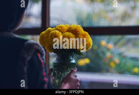Gelbe Blumen in einem Glas gefüllt mit Wasser Stockfoto