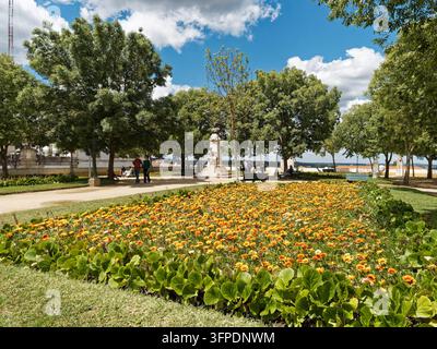 Üppige Blumenbeete und Marmorstatue im öffentlichen Garten am römischen Tempel der Diana, Évora, Portugal Stockfoto