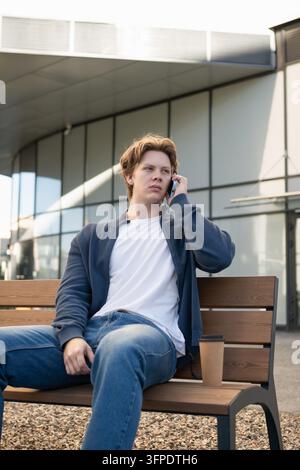 Junger Mann telefoniert im Freien mit dem Smartphone Stockfoto