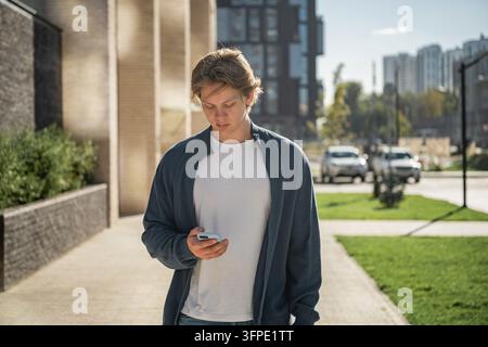 Junger Mann mit Smartphone im freien Stockfoto